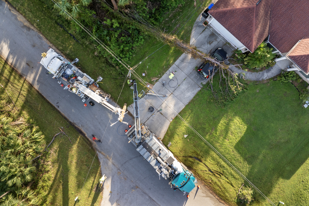 Aerial view of electrician workers repairing damaged power lines after hurricane in Florida suburban area